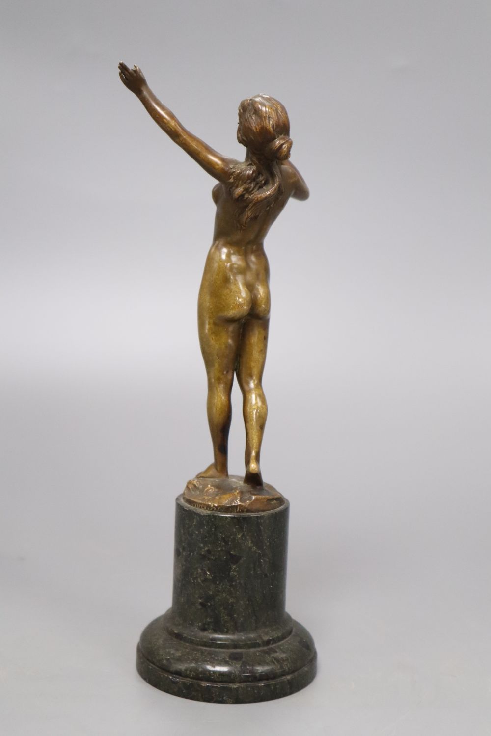 An early 20th century bronze of a nude lady, indistinctly signed, on marble base, overall height 25cm